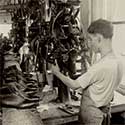 Man using a lasting machine to produce shoes.